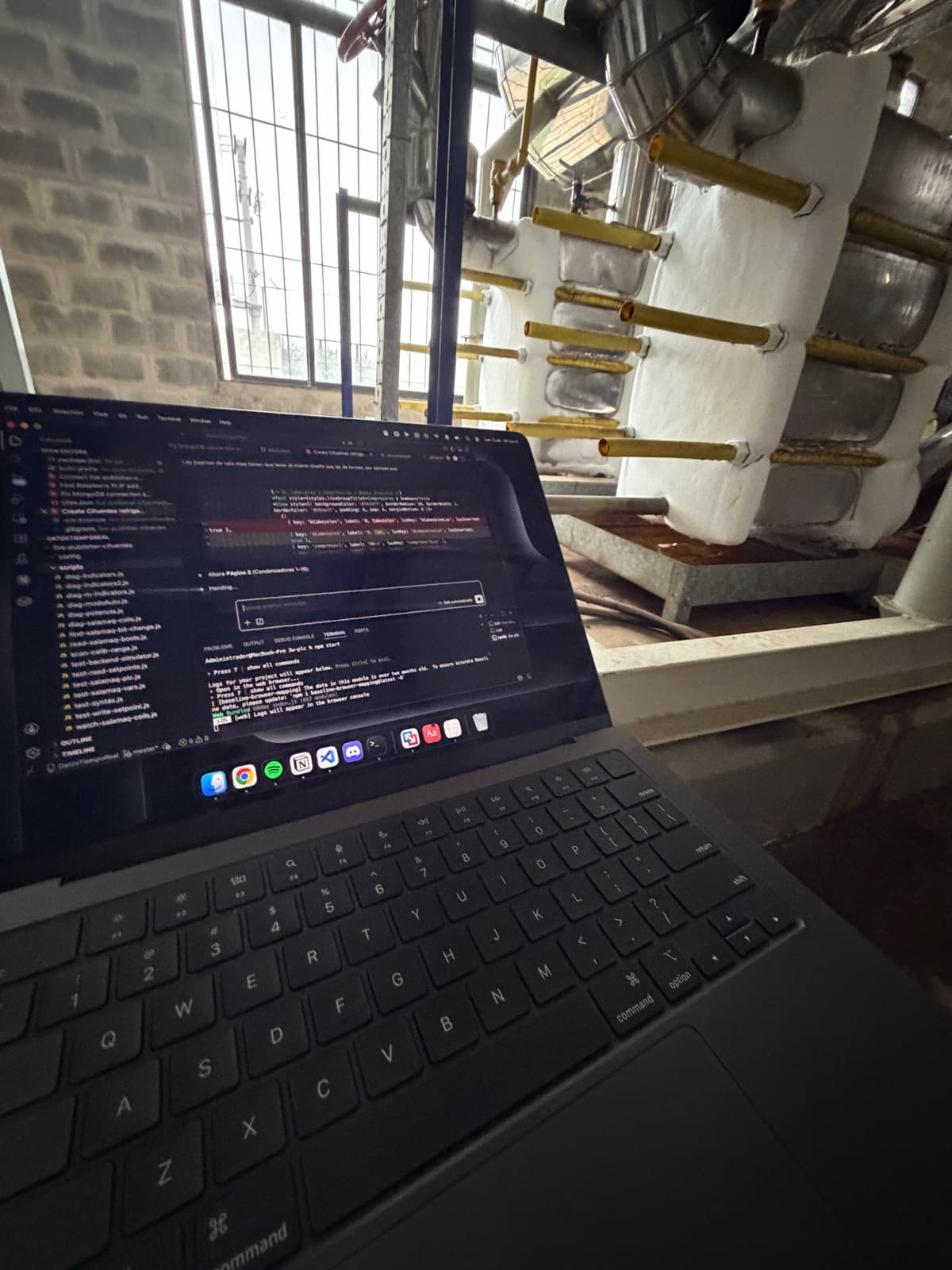 Computadora con código abierto frente a un equipo industrial durante una visita a planta de 3W.